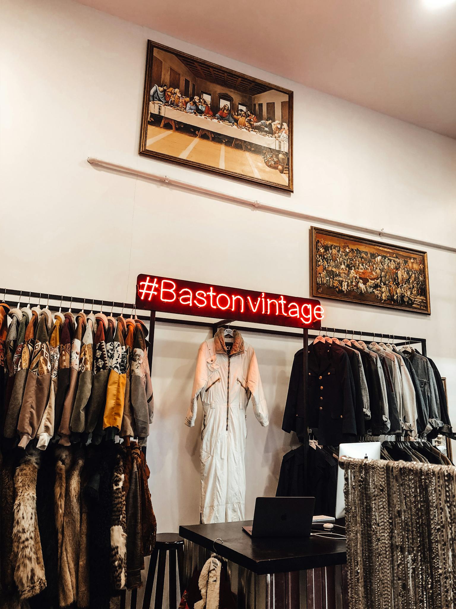 Explore a chic vintage clothing boutique featuring trendy garments and a vibrant neon sign.